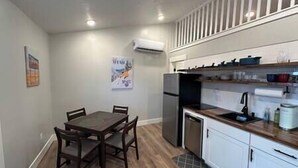 A compact kitchen with a dining table and chairs, a refrigerator, and a sink. - Modern 1BR Retreat • Near Sugar House & Downtown (Salt Lake City)