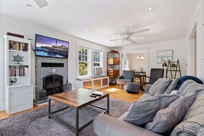 A modern living room with a fireplace, a television, and a cozy seating area.