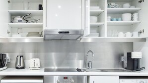 A modern kitchen with stainless steel appliances, white cabinetry, and a built-in oven. - Blueground | Saint Germain, nr the Sorbonne (Paris)