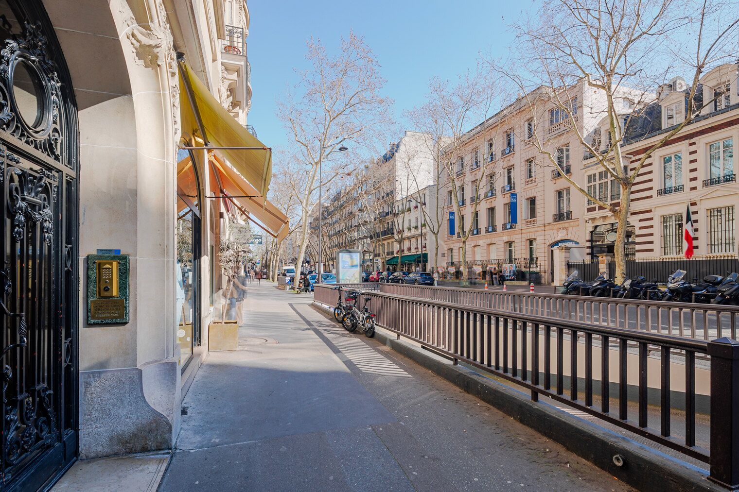Une rue étroite bordée de bâtiments historiques, avec un trottoir et des vélos garés.