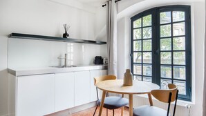 Eine moderne Küche mit weißen Schränken, einer schwarzen Arbeitsplatte und einem Fenster mit Blick auf Gebäude.