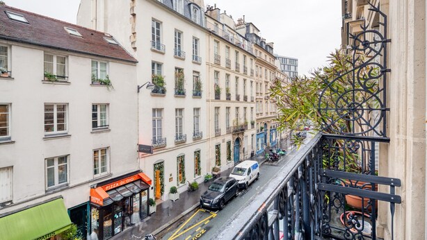 A street view with buildings, a car, and a bicycle. - Blueground | St Placide, balcony, nr Bon Marché (Paris)