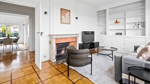 Un salon moderne doté d’une cheminée, d’un téléviseur et d’une bibliothèque intégrée.