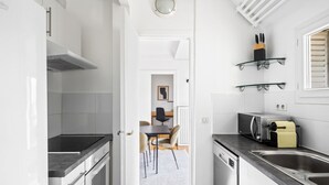 Une cuisine moderne équipée d’une cuisinière, d’un four à micro-ondes et d’un grille-pain. On y trouve également un coin repas avec des chaises et une table.