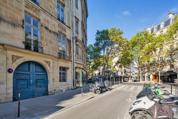 A street with parked scooters and a blue door on a building.