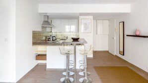 Eine moderne Küche mit einer zentralen Kochinsel, Barhocker und einer kleinen Bar.