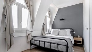 A bedroom with a bed, a nightstand, and a window with curtains. - Blueground | Montorgueil, concierge, furnished (Paris)