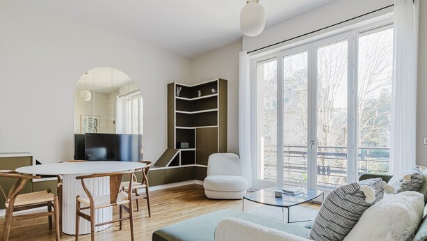 A modern living room with a round table, wooden chairs, a white sofa, and a glass coffee table. - Blueground | Trocadero, elevator, nr Eiffel Tower (Paris)