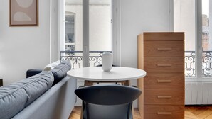 Ein modernes Wohnzimmer mit einer Couch, einem runden Tisch und einer Holzkommode.