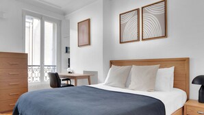 Ein Schlafzimmer mit einem hölzernen Bett, einem Schreibtisch und einem Stuhl.