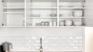 A kitchen with white cabinets, a stainless steel sink, and a tiled backsplash. - Blueground | Saint Lazare, elevator, near opera (Paris)