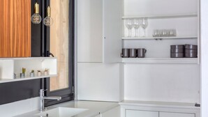 Une cuisine moderne avec un plan de travail blanc, un meuble en bois et une fenêtre donnant sur un beau paysage.