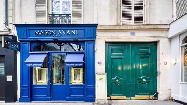 Une devanture bleue avec l’enseigne « MAISON AVANI PARIS » et deux vitrines portant les inscriptions « Haute Gemmologie » et « Spécialiste du Saphir ».