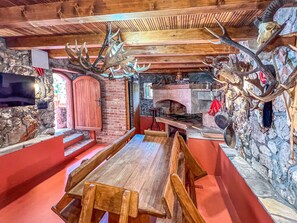 Een rustiek interieur met een stenen muur, houten meubilair en decoraties van gewei.