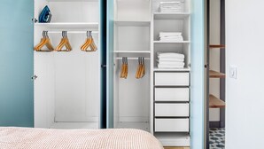 A bedroom with a bed, a wardrobe with hanging space, and a closet with shelves. - Blueground | Invalides, concierge, a/c, nr museums (Paris)