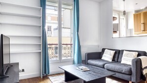 A modern living room with a grey sofa, a coffee table, and a TV stand. - Blueground | Montparnasse, concierge, nr train (Paris)