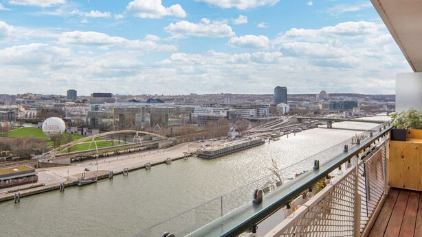 A cityscape with a river, bridges, and modern buildings. - Blueground | Chardon Lagache, balcony & concierge (Paris)