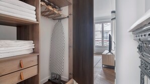 A modern bathroom with a wooden vanity, a towel rack, and a shower area.