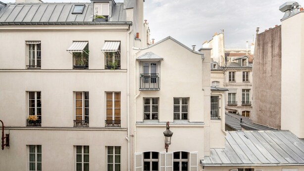 A row of European-style buildings with uniform facades, multiple windows, and balconies.