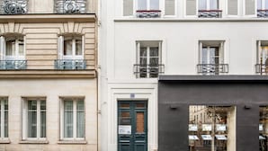 A building with a green door and a sign reading "CAROLINA". - Blueground | Vendome/Saint Honoré, furnished (Paris)