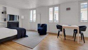 A modern bedroom with a bed, a desk, and two chairs. - Blueground | Pigalle, furnished, nr opera (Paris)