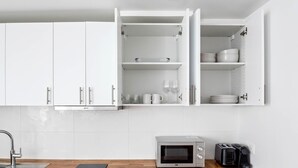 A modern kitchen with white cabinets, a built-in microwave, and a coffee maker. - Blueground | Montorgueil, intercom, nr Les Halles (Paris)