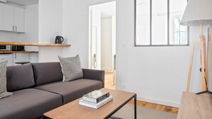 A modern living room with a grey sofa, a wooden coffee table, and a bookshelf. - Blueground | Montorgueil, intercom, nr Les Halles (Paris)