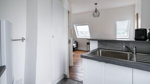 Una cocina moderna con un lavamanos grande, una ventana y una lámpara en el techo.