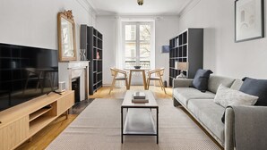Un salon moderne avec une télévision, un canapé, une table basse et des livres.