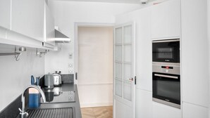 Eine moderne Küche mit einem Bosch-Backofen, einer eingebauten Mikrowelle und einer Kaffeemaschine.