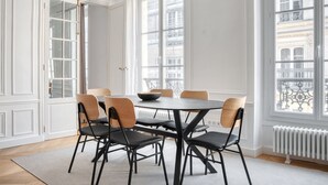 Ein Esszimmer mit einem runden Tisch, sechs Stühlen und einer Schüssel.