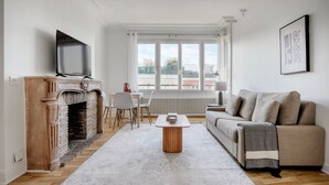 En stue med pejs, fjernsyn, sofa og spiseplads med stole og bord.