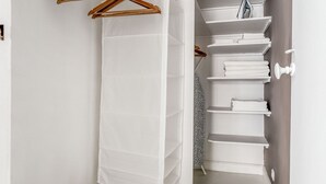Ein helles Badezimmer mit einem weißen Handtuchhalter, einer weißen Handtuchablage und einem Handtuchhalter mit Holzgriffen.