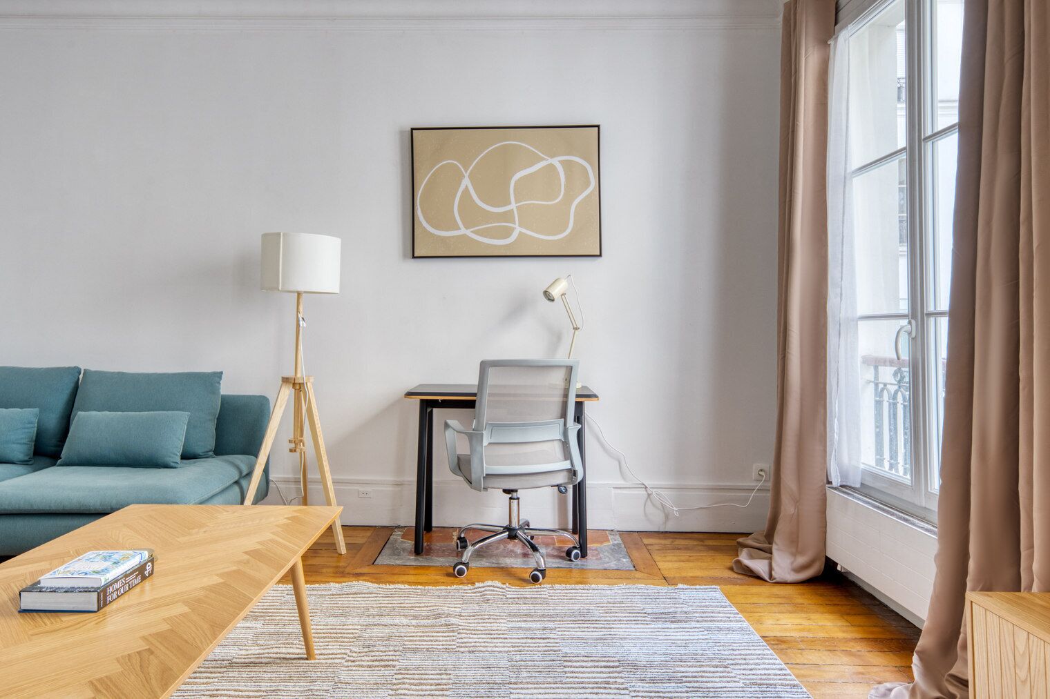 Ein modernes Wohnzimmer mit einer Couch, einem Couchtisch aus Holz, einem Schreibtisch mit Stuhl, einer Stehlampe und einem großen Fenster mit Vorhängen.