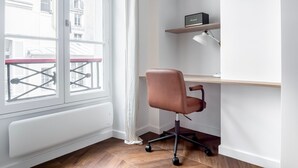 A corner office with a desk, chair, and a shelf with a radio. - Blueground | Saint-Honoré, nr opera (Paris)