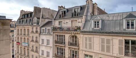 A row of historic European buildings with multiple stories, balconies, and classic architectural details.