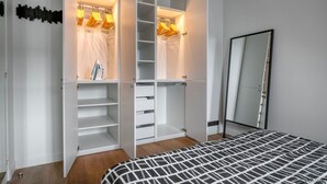 Ein Schlafzimmer mit einem Bett, einem Kleiderschrank und einem Spiegel.
