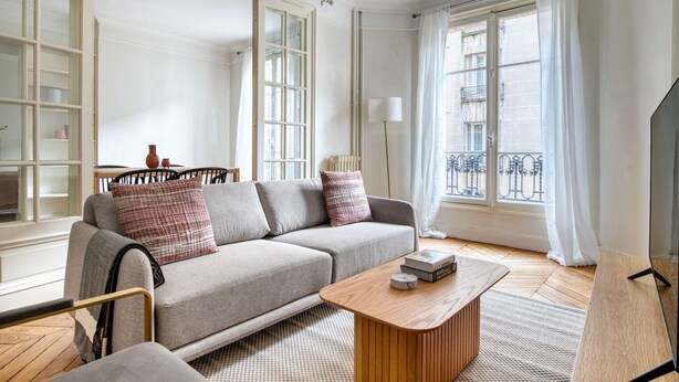 A modern living room with a grey sofa, a wooden coffee table, and a bookshelf. - Blueground | Vaugirard, lively area (Paris)