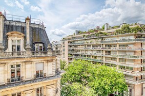 A multi-story building with balconies, large windows, and a prominent central tower. - Blueground | Trocadéro, a/c, nr dining & garden (Paris)