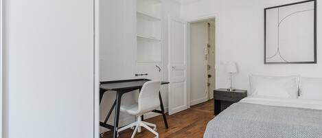 Une chambre à coucher avec un lit, un bureau et une chaise.