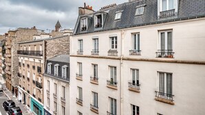 Une rangée d’immeubles à étages, caractérisés par une architecture résidentielle urbaine typique, avec des façades aux fenêtres uniformes et des balcons.