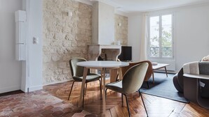 A modern living room with a stone wall, a fireplace, a round table, and a sofa.