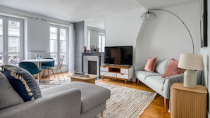 Ein modernes Wohnzimmer mit einer Couch, einem Couchtisch, einem Fernseher und einem Kamin.