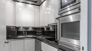 A modern kitchen with stainless steel appliances, a granite countertop, and white cabinetry. - Blueground | La Motte-Picquet Grenelle, nr seine (Paris)