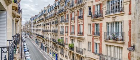 Una hilera de edificios históricos con balcones ornamentados y una calle en el medio.