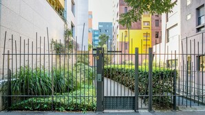 A gated residential area with a modern apartment building, a yellow facade, and a black metal gate. - Blueground | Gibauderie, balcony, nr station (Paris)