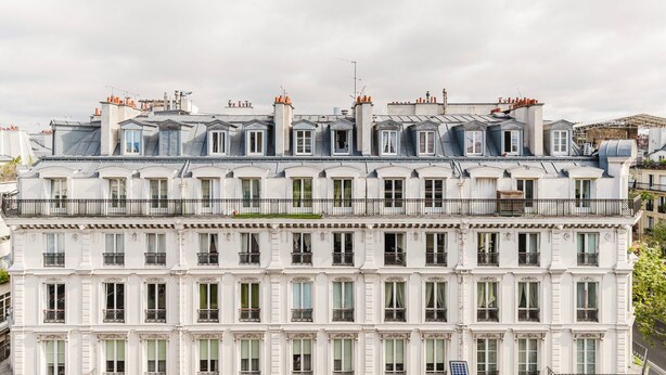 A multi-story building with a classic architectural style, featuring balconies and a flat roof with chimneys. - Blueground | Les Halles, close to Eiffel Tower (Paris)