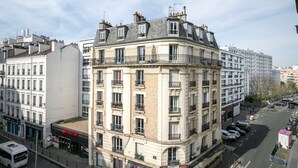 A multi-story building with a corner facade, featuring balconies and a mix of brick and plaster exteriors. - Blueground | La Motte-Picquet Grenelle, near shops (Paris)