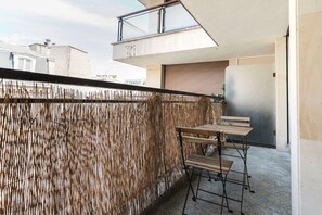 Enjoy dining or relaxing on the balcony with a table and two chairs.