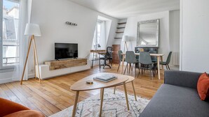 A modern living room with a flat-screen TV, wooden coffee table, and a gray sofa. - Blueground | Jardin des Plantes, nr open markets (Paris)